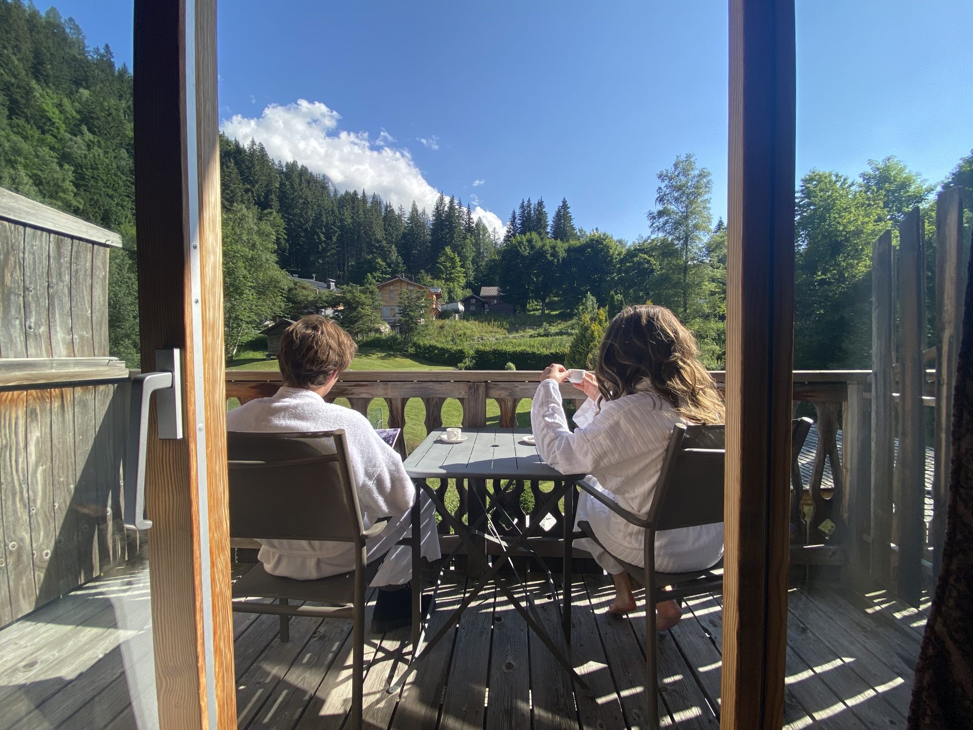 couple sur une terrasse de chambre buvant son café du chalet hotel & spa jeu de paume Chamonix Mont-Blanc