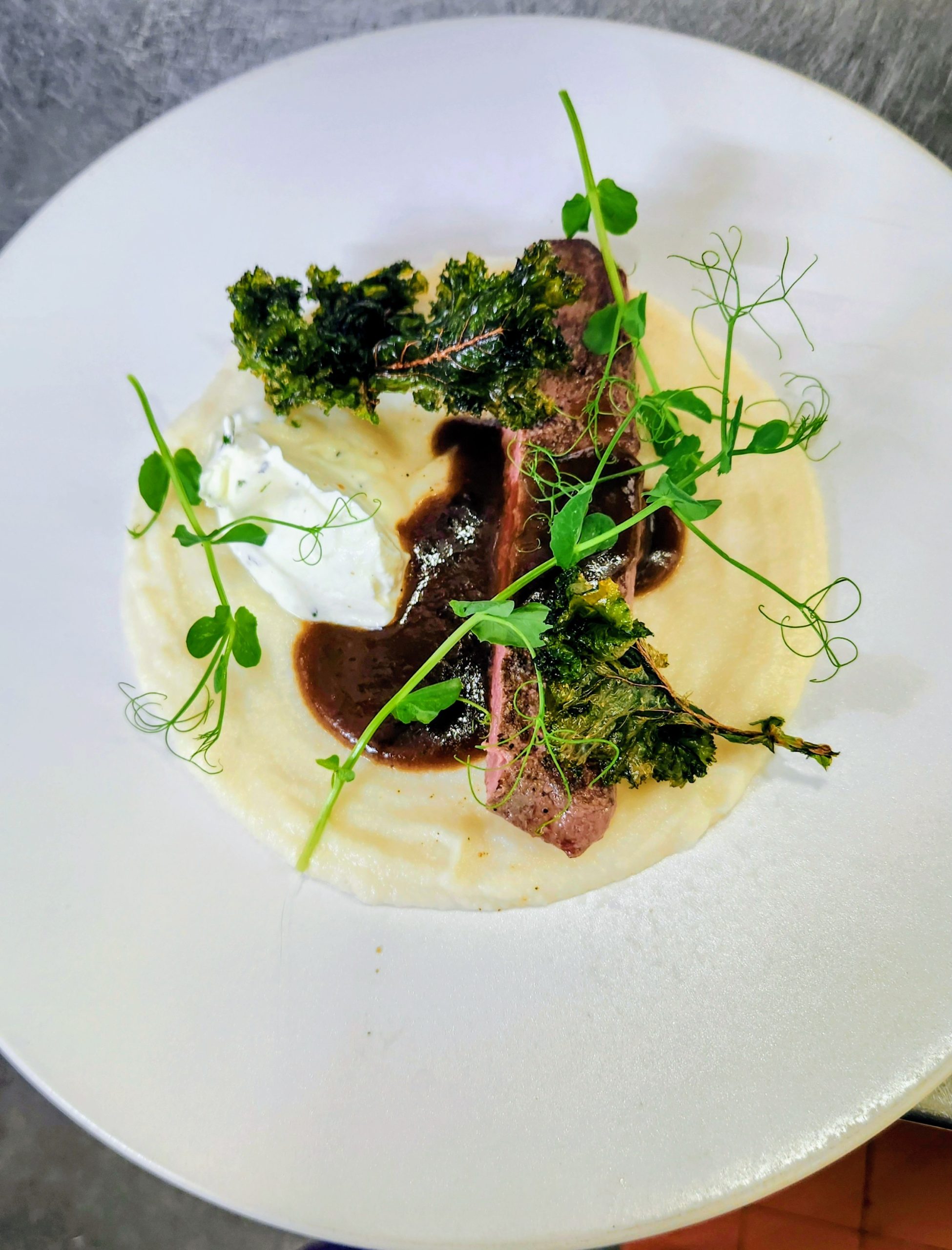 Filet d'agneau, mousseline chou fleur, chou kale frit, mascarpone menthe, raifort et citron vert et jus réduit.