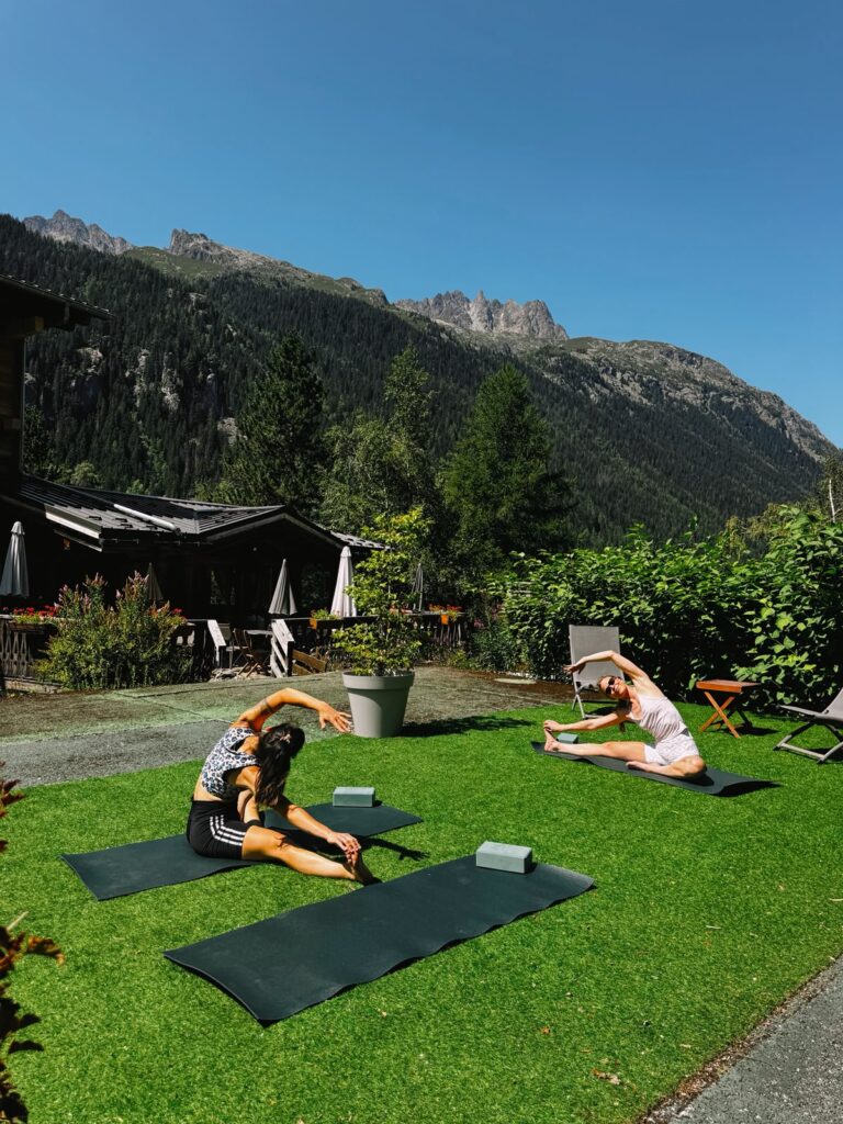 Séance de yoga et étirements dans le jardin de l’Hôtel Jeu de Paume à Chamonix, face aux massifs du Mont-Blanc